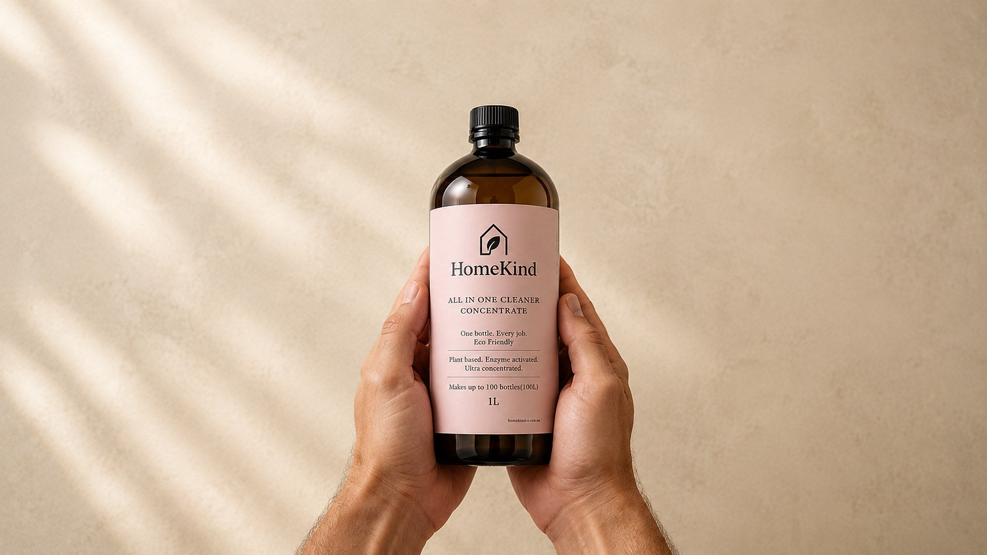 Hands holding a bottle of HomeKind concentrate